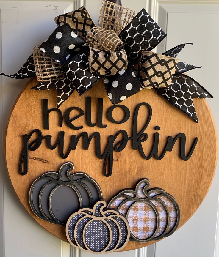 Rustic autumn wreath with Hello Pumpkin sign and decorative pumpkins, perfect for fall door decor.