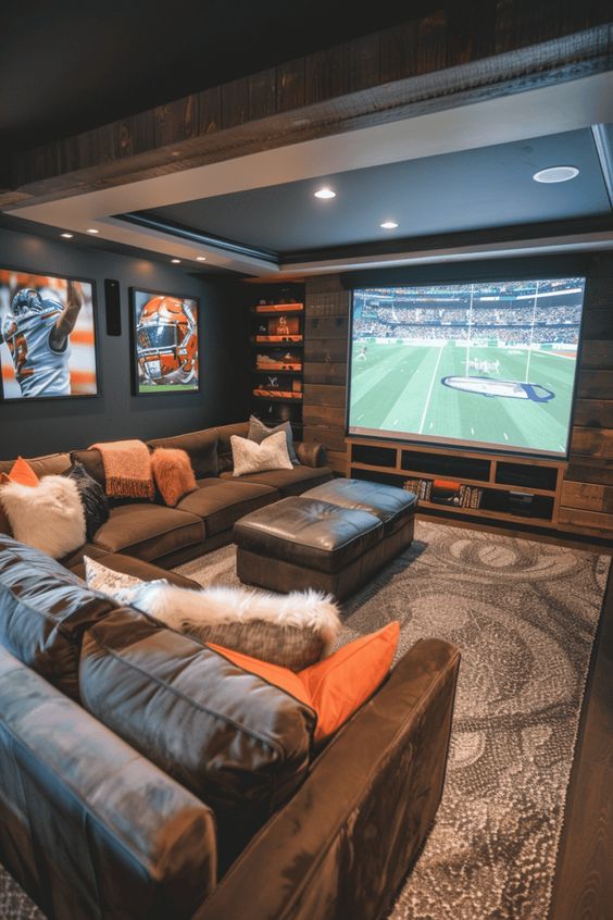 Cozy home theater with large screen, sectional sofa, pillows, and sports decor for an immersive viewing experience.