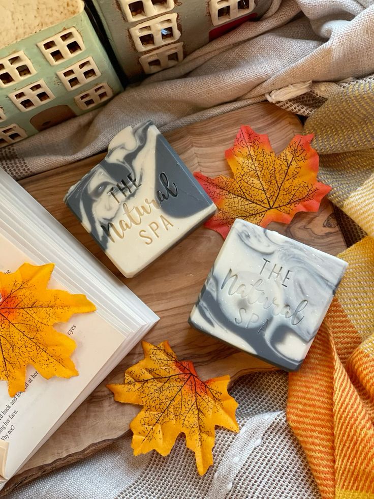 Autumn-themed natural spa soap with decorative leaves on a cozy wooden background.