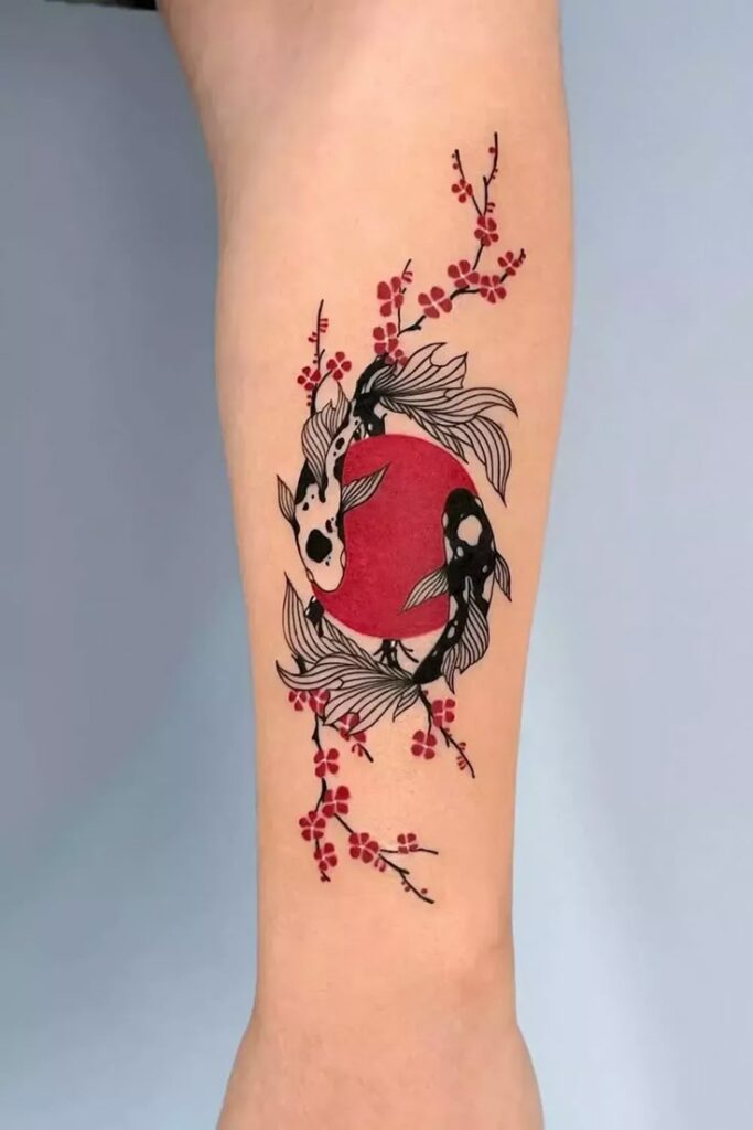 Ornamental koi fish tattoo with red sun and cherry blossoms on forearm. Japanese-style ink art design.