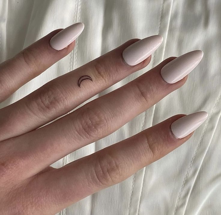 Neutral nails with crescent tattoo on finger. Perfect minimalist nail art inspiration and design.