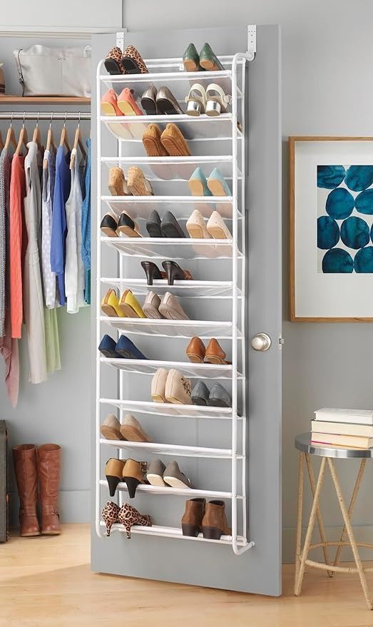 Hanging shoe organizer on a door with multiple pairs of shoes in a neatly organized closet with clothes and accessories.