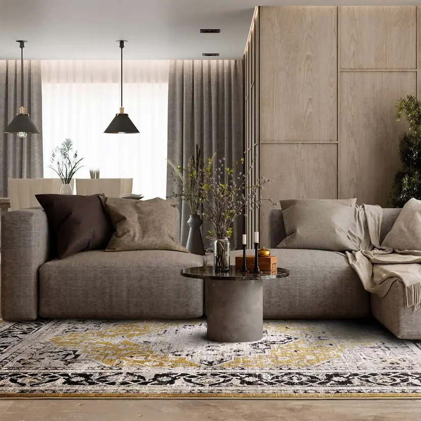 Modern living room with gray sofa, decorative pillows, round coffee table, and stylish rug. Cozy and elegant decor.