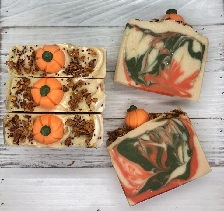 Handmade pumpkin-themed soap bars with autumnal colors and decorative elements on a wooden background.