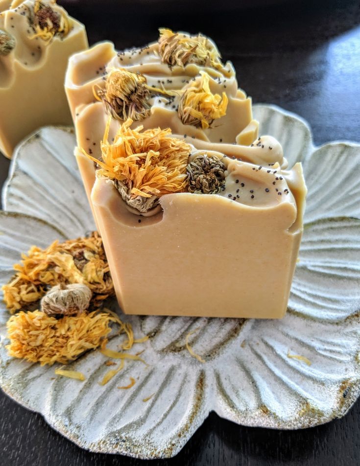 Handmade soap with dried flowers and seeds on a decorative plate. Artisan soap with natural ingredients.