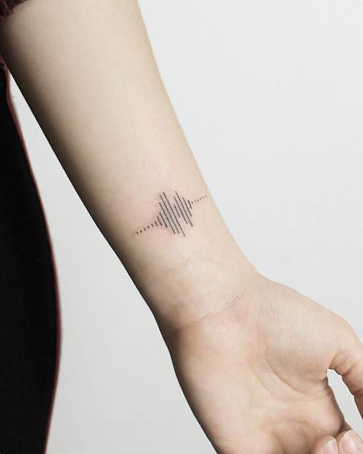 Minimalist soundwave tattoo on forearm, black ink, simple design, wrist area.