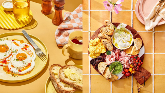 Delicious breakfast spread with fried eggs, toast, and a charcuterie board on a warm yellow backdrop.