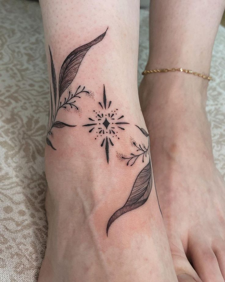 Ornamental floral ankle tattoo with geometric design and delicate line work.