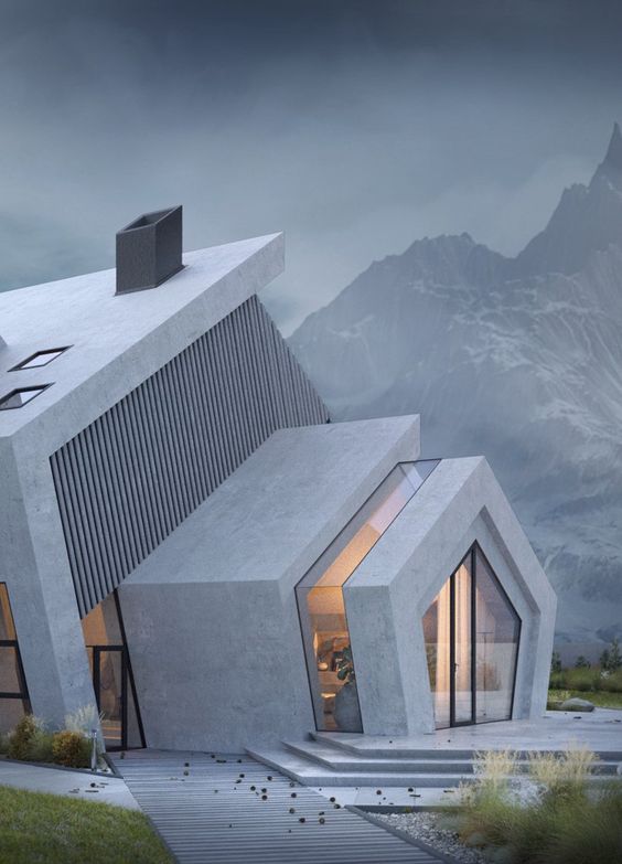 Modern concrete house with large windows set against a dramatic mountain backdrop, showcasing contemporary architecture.