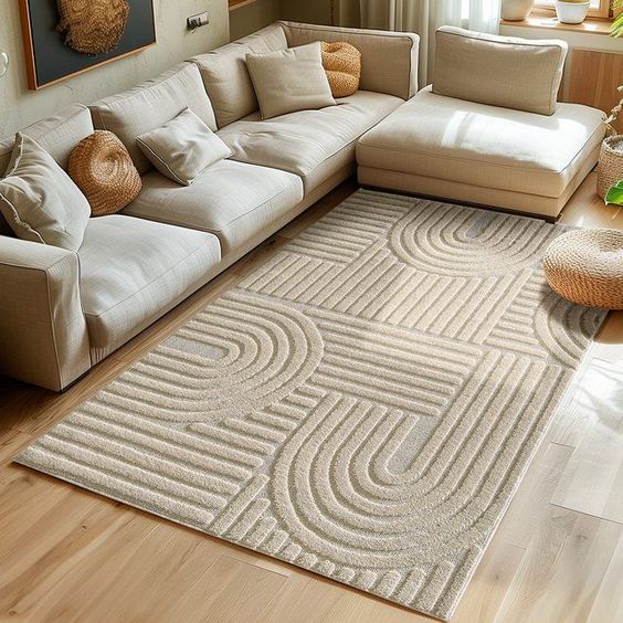 Stylish beige living room with geometric-patterned rug and cozy sectional sofa in bright, natural light.