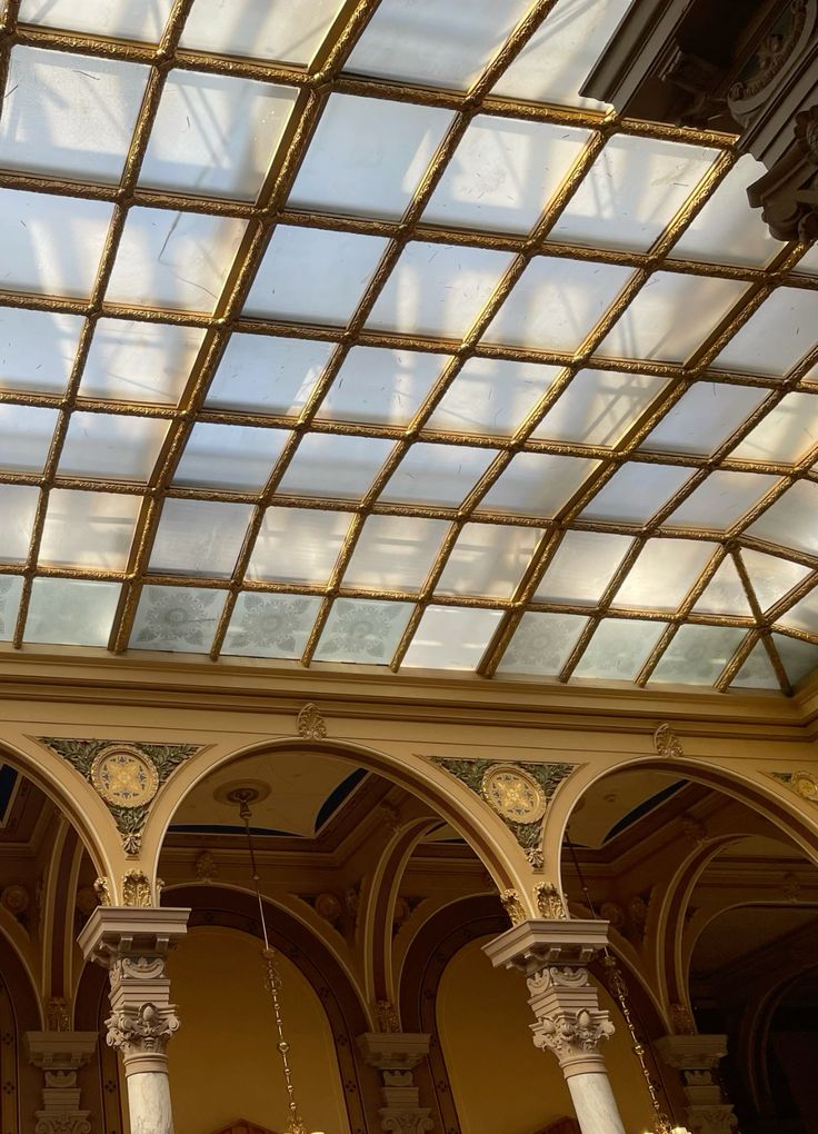 Ornate interior with arched columns and vintage glass ceiling, showcasing elegance and architectural beauty.