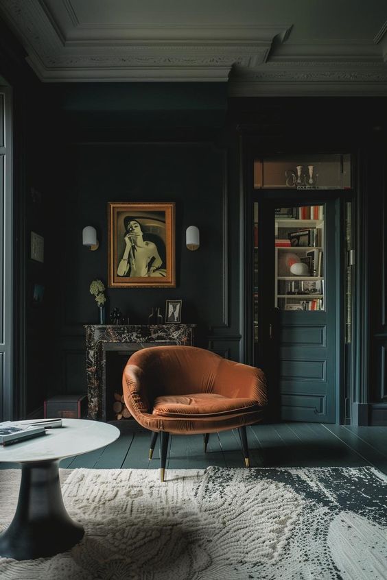 Elegant dark living room with velvet chair, artwork, marble fireplace, and modern decor. Cozy, sophisticated interior design.