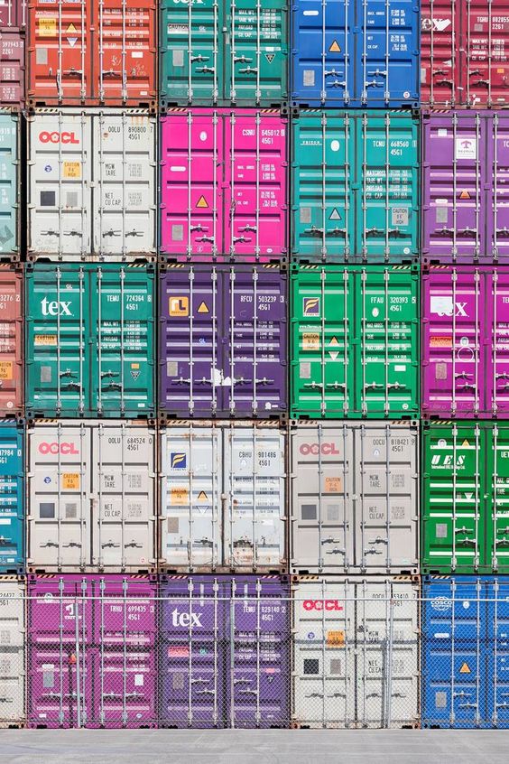 Colorful stacked shipping containers at a port, showcasing global trade and logistics.