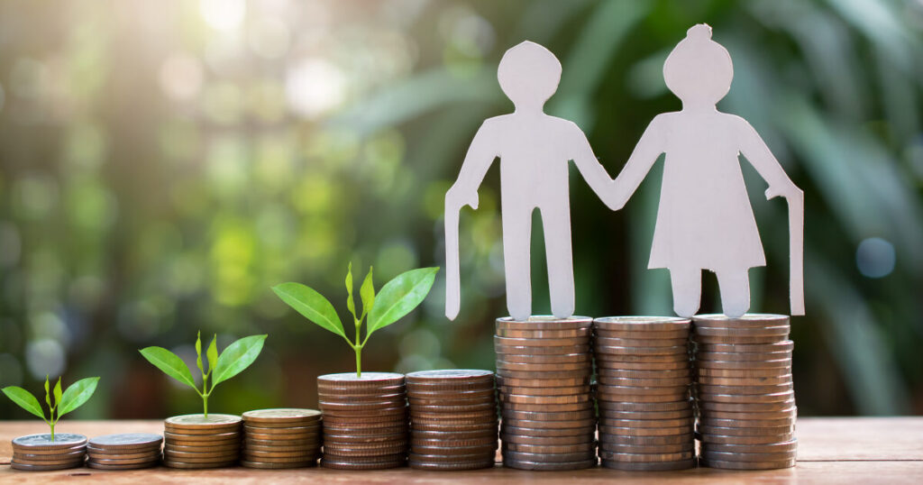 Elderly couple figurine atop stacked coins and growing plants, symbolizing financial growth and retirement savings.