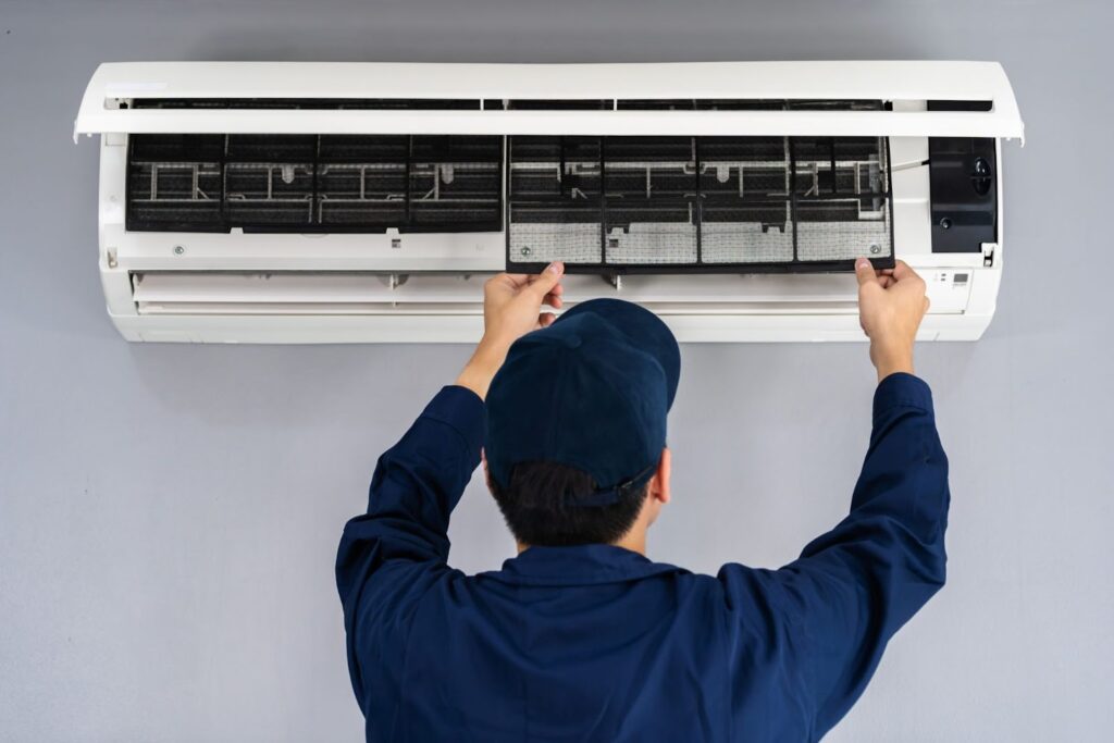 Technician cleaning air conditioner filter for improved efficiency and airflow.