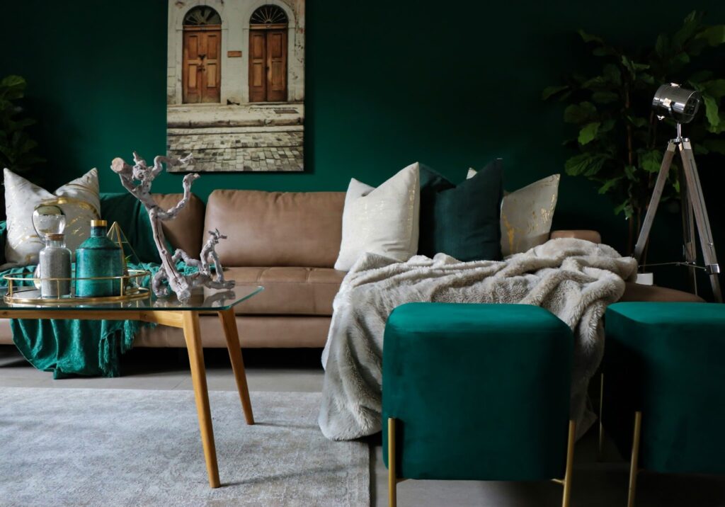 Stylish living room with green walls, tan sofa, elegant decor, and a modern floor lamp. Cozy, chic interior design.