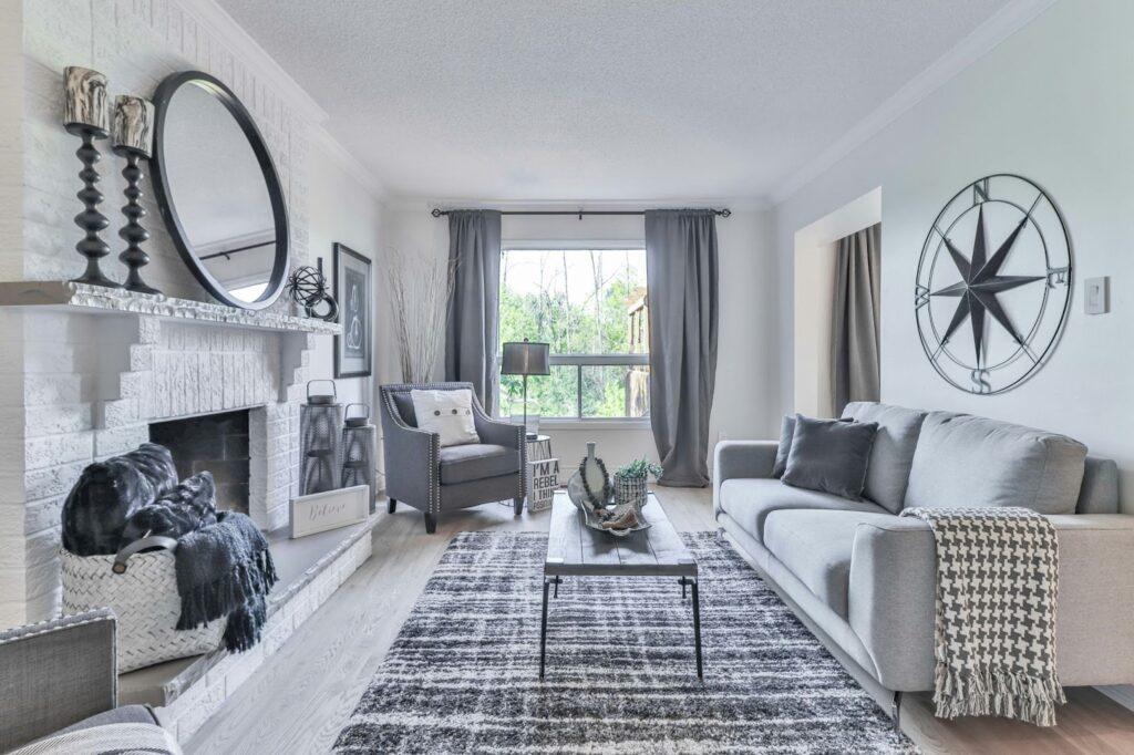 Modern living room with grey sofa, fireplace, and decorative accents. Bright, cozy interior with stylish furniture.