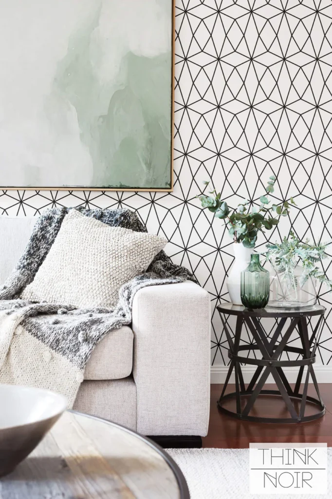 Stylish living room with geometric wallpaper, cozy sofa, and modern side table with plants in vases.