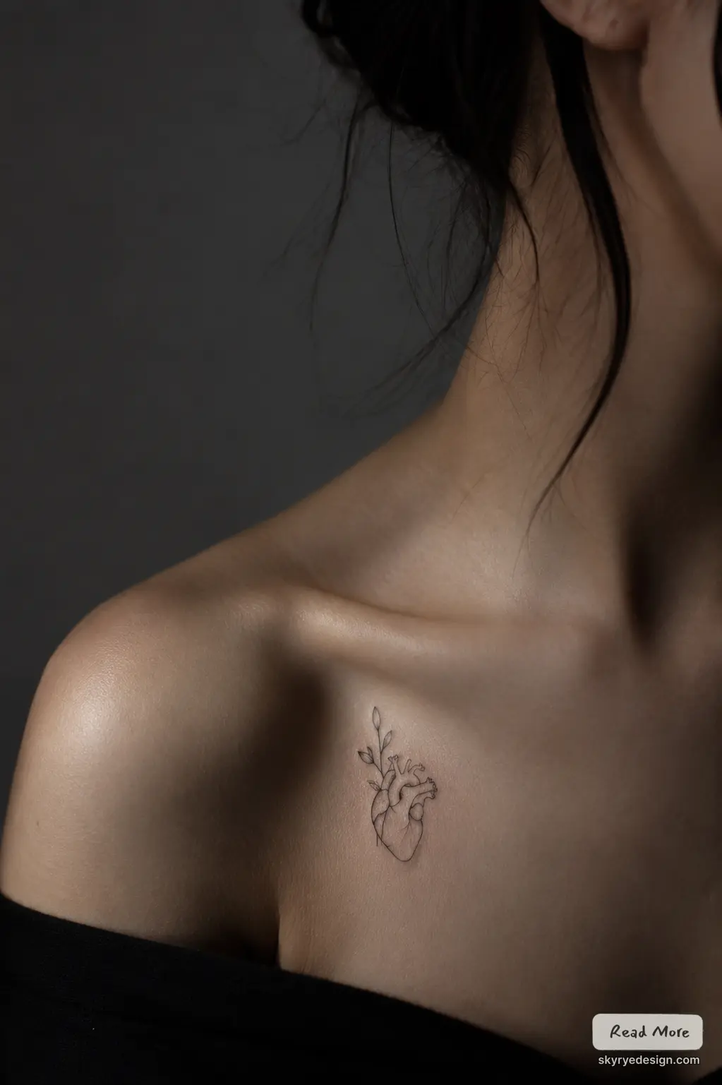 heart-minimal Fine-line minimalist anatomical heart tattoo with budding leaves on collarbone, close-up skin detail | Sky Rye Design Fine-line minimalist anatomical heart tattoo with budding leaves on collarbone, close-up skin detail
