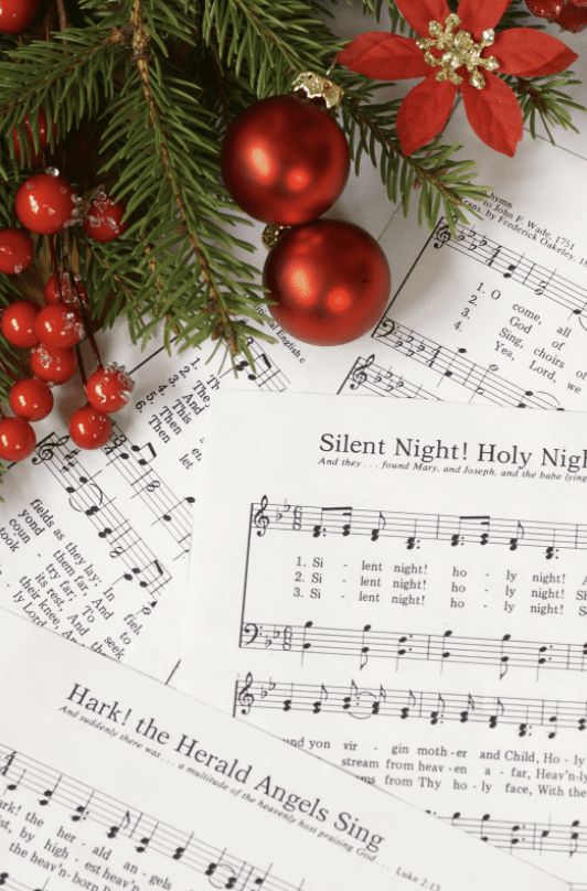 Christmas sheet music with festive decorations featuring holly, poinsettia, and red ornaments.