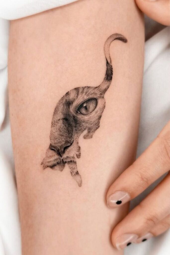 Abstract cat tattoo on forearm, intricate design blending into skin, showcasing realistic feline eye and fur details.