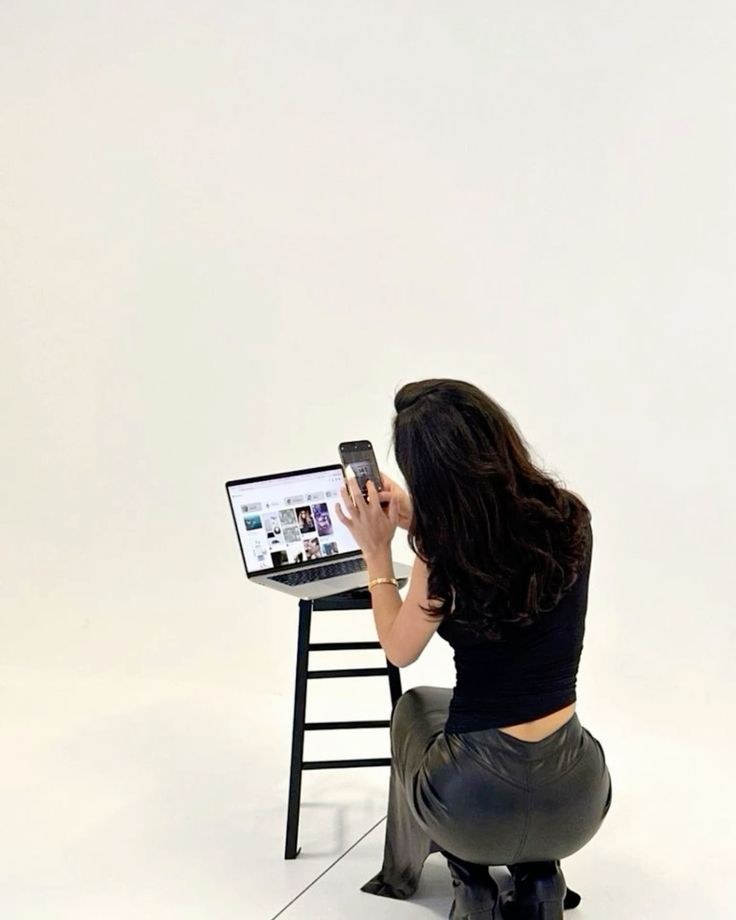 Person using a smartphone to capture laptop screen images, focusing on technology and modern communication.