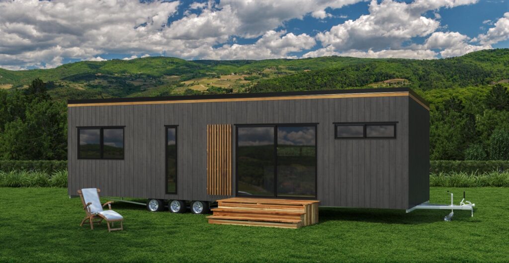 Modern tiny house on wheels in a scenic green landscape, with a wooden patio and outdoor chair.