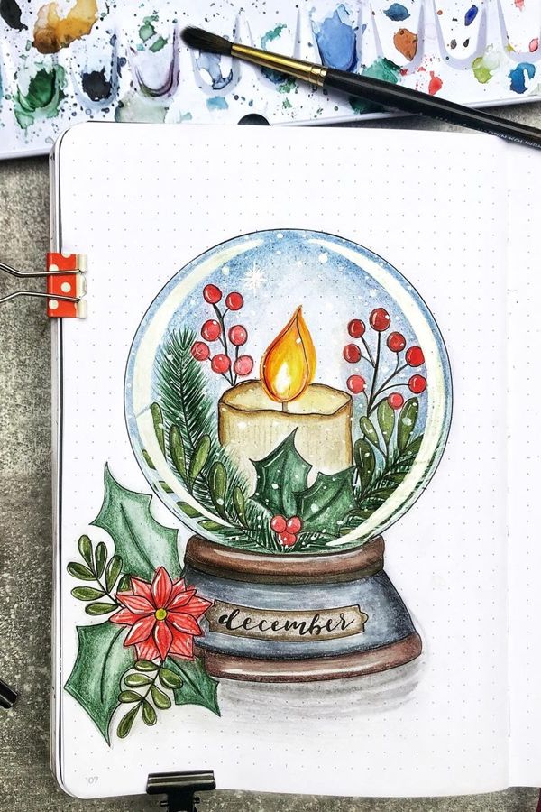 Watercolor snow globe with candle, holly, and berries illustration labeled December with festive greenery.