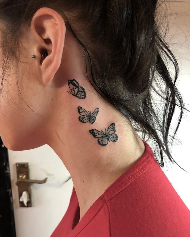 Neck tattoo featuring three black butterflies on a woman's skin, wearing a red shirt.