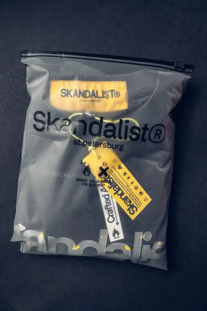 Skandalist® black garment packaged in frosted resealable bag with yellow brand tag — Skandalist St. Petersburg apparel