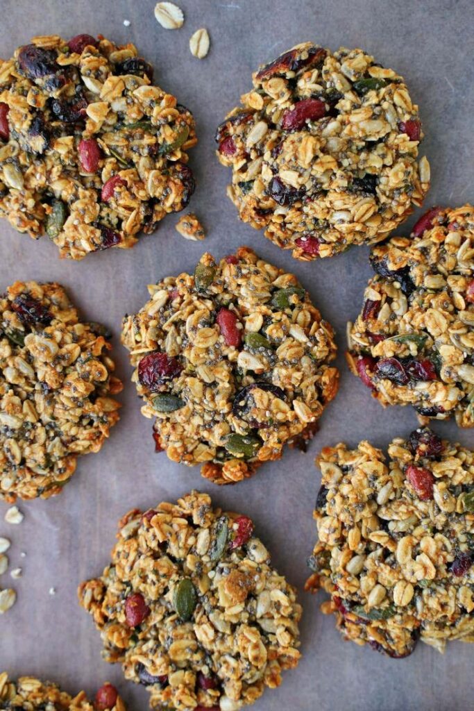 Homemade granola cookies with oats, seeds, and dried fruit on parchment paper, healthy snack option.