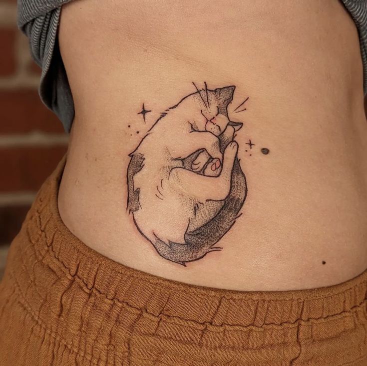 Tattoo of a sleeping cat cradled in hands on a person's side, symbolizing comfort and warmth.