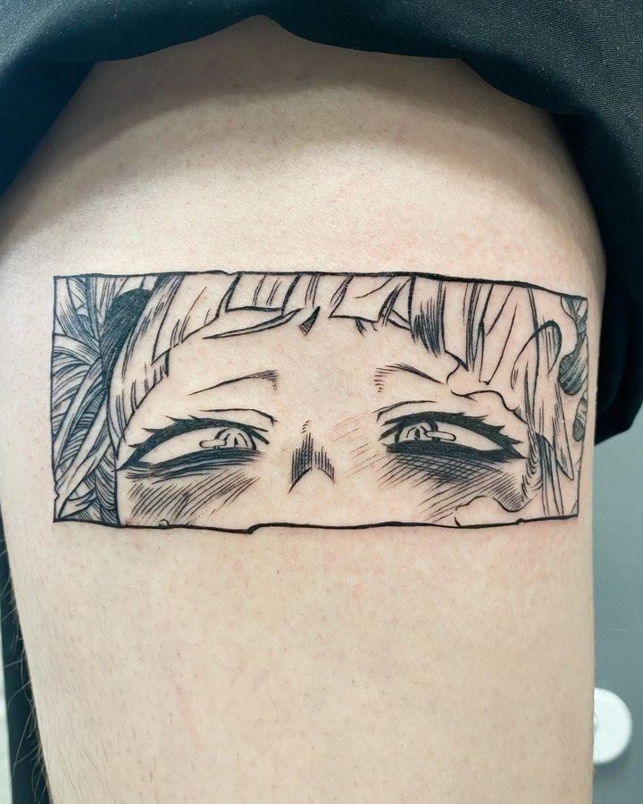 Detailed manga-style tattoo of a character's expressive eyes on skin.