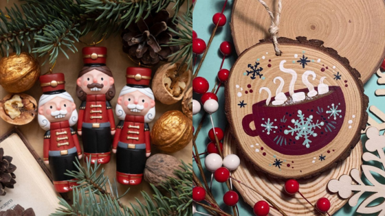 Festive Christmas scene with nutcracker ornaments, pinecones, walnuts, and a hot cocoa decoration on wooden slices.