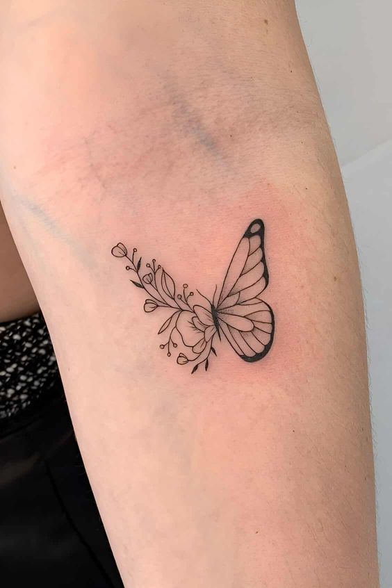 Minimalist butterfly tattoo design with flowers on inner arm.