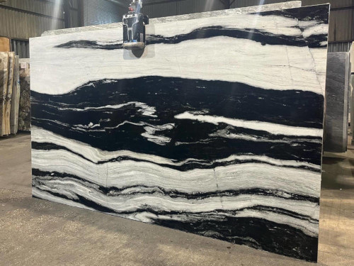 Black and white marble slab with bold stripes in a warehouse setting.