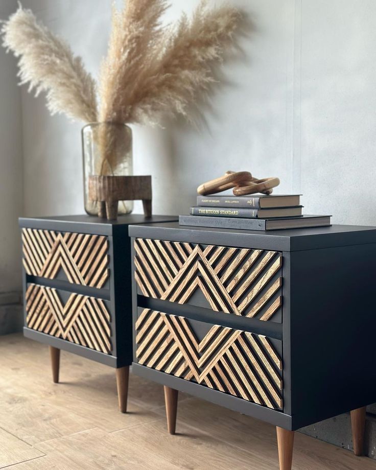 Modern wooden cabinets with geometric patterns, topped with pampas grass and books on a light wood floor.