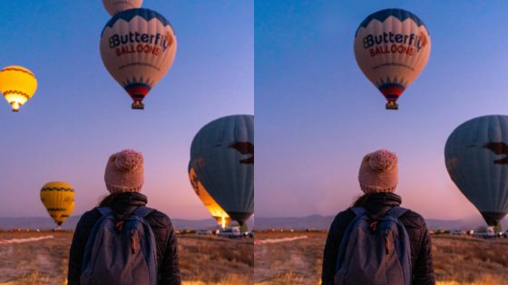 Person watches colorful hot air balloons at sunrise in a scenic landscape.