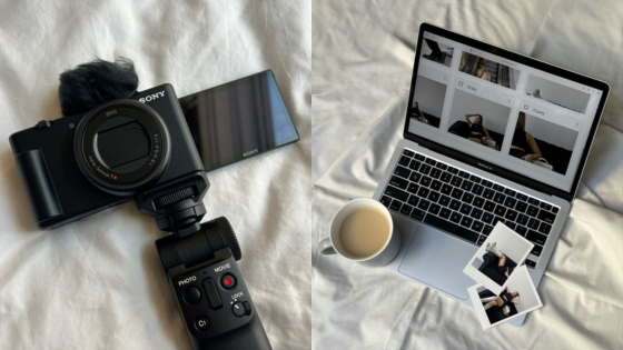 Camera and laptop on bed with a cup of coffee and photos, depicting a cozy creative workspace.