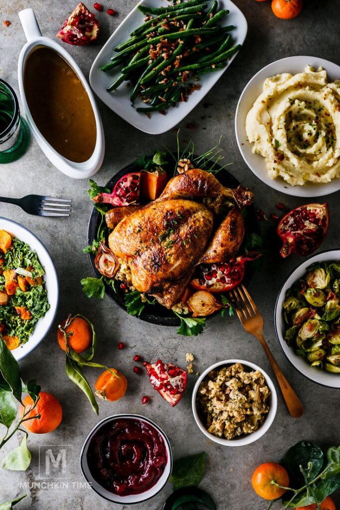 Festive Thanksgiving feast with roast turkey, mashed potatoes, green beans, and assorted sides on a rustic table setting.