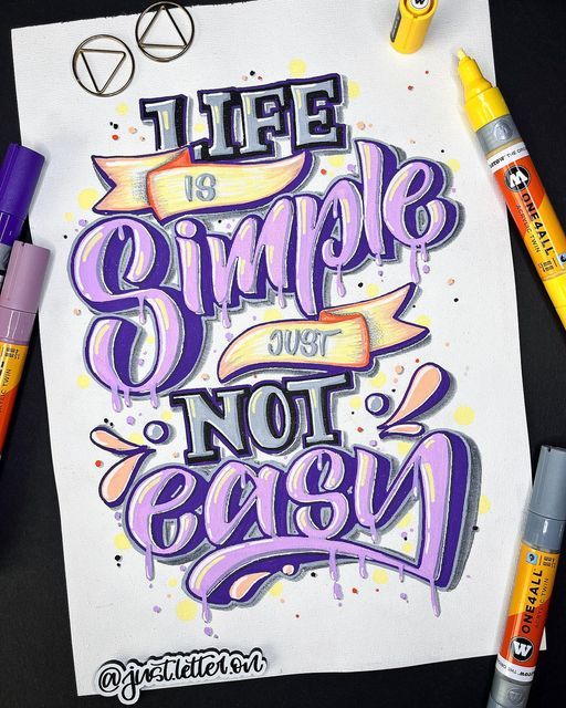 Colorful hand-lettering art reading Life is simple, just not easy surrounded by markers on paper background.