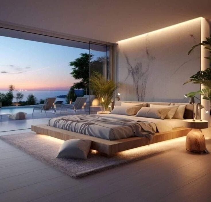 Modern luxurious bedroom with ocean view, ambient lighting, stylish decor, and outdoor seating at sunset.