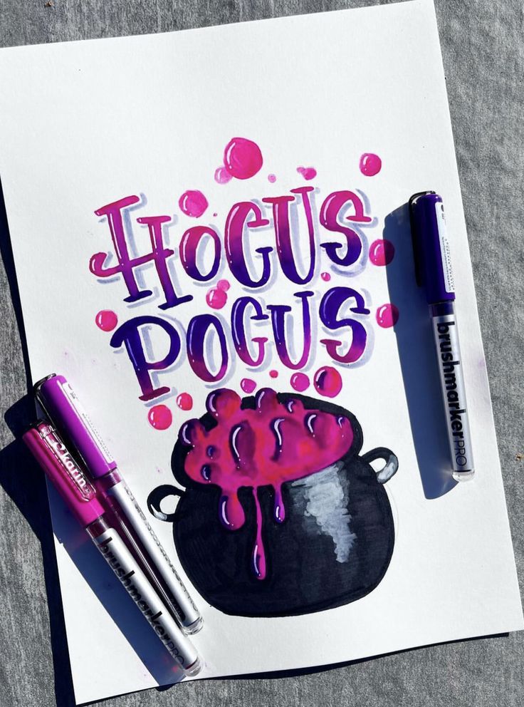 Hocus Pocus lettering with cauldron illustration in vibrant pink and purple colors, surrounded by markers.