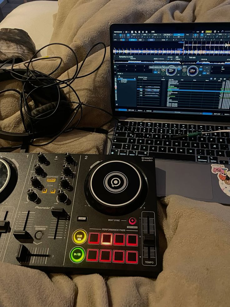 DJ mixing setup with laptop and controller on a cozy blanket, ready for music production and mixing.