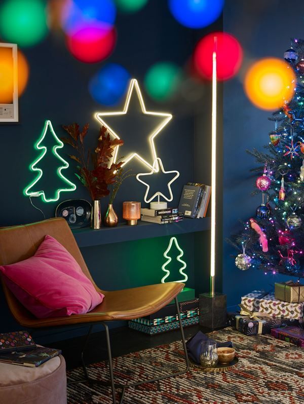 Cozy holiday scene with neon Christmas tree and star lights, festive decor, and illuminated gifts near a Christmas tree.