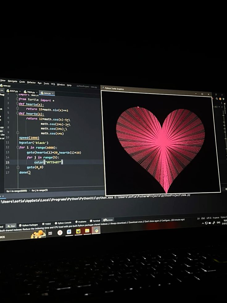 A laptop display shows Python code and a generated pink heart shape using Turtle graphics on a dark background.