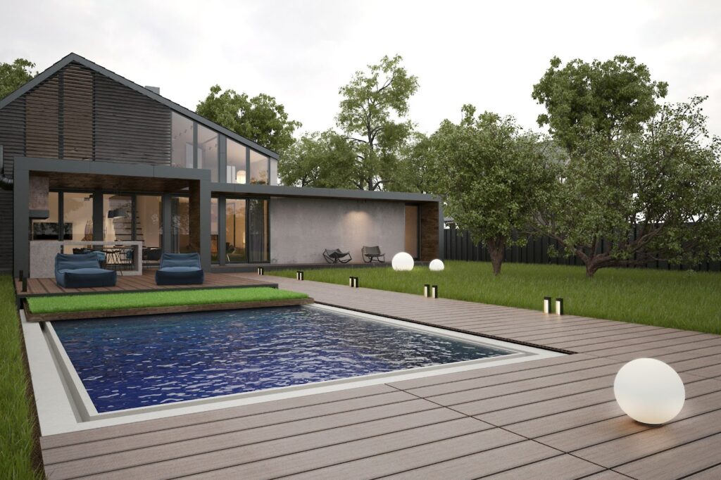 Modern house with glass facade, wooden deck, and a pool surrounded by greenery and outdoor lighting.