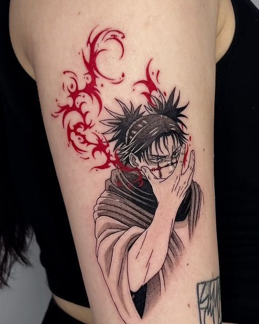 Anime-inspired tattoo featuring a character with red flames on upper arm, showcasing detailed art and vibrant colors.