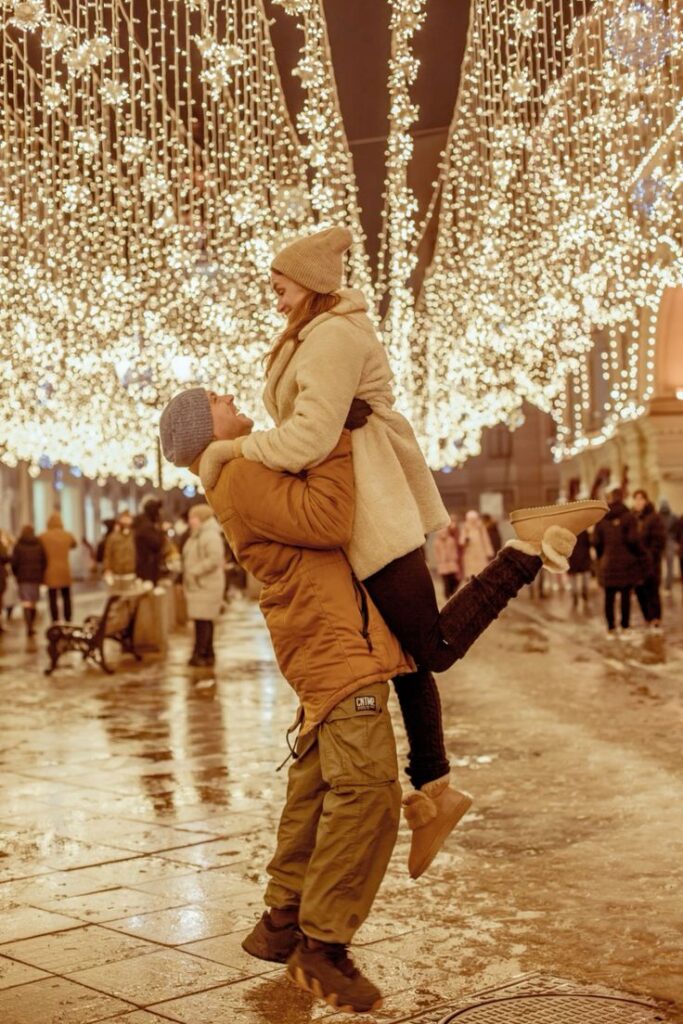 Лавстори Москва Новый год Couple celebrates under festive winter lights in city street, creating a romantic holiday atmosphere. | Sky Rye Design Couple celebrates under festive winter lights in city street, creating a romantic holiday atmosphere.