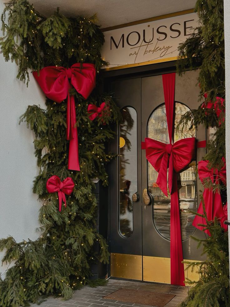 Новогодний интерьер кофейни эстетика Festive bakery entrance decorated with lush greenery and bright red bows under a Mousse sign. | Sky Rye Design Festive bakery entrance decorated with lush greenery and bright red bows under a Mousse sign.